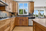 This beautifully appointed kitchen features custom wood cabinetry and a striking slate tile backsplash.
