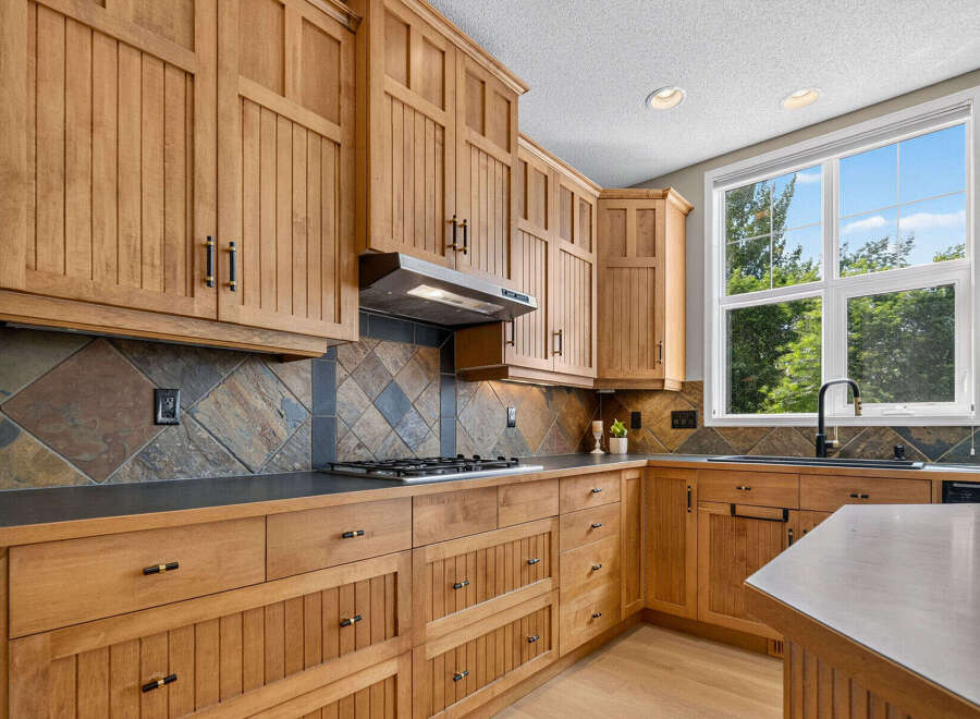 This beautifully appointed kitchen features custom wood cabinetry with intricate detailing and ample storage.
