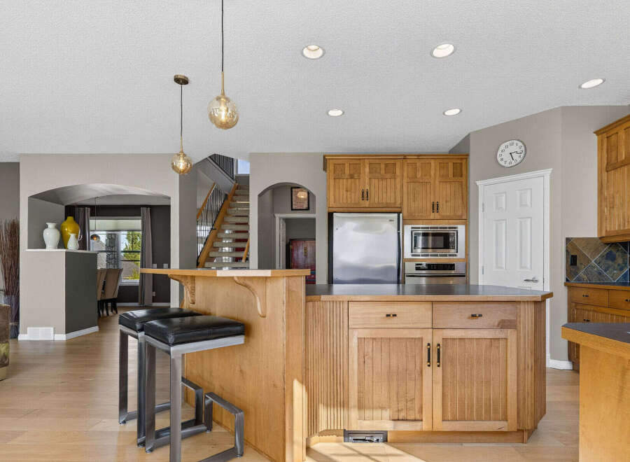 This spacious kitchen boasts beautiful natural wood cabinetry and a large island, perfect for meal preparation and casual dining.