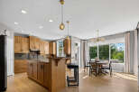 This spacious kitchen boasts beautiful natural wood cabinetry and a large island with seating, perfect for casual dining or entertaining.