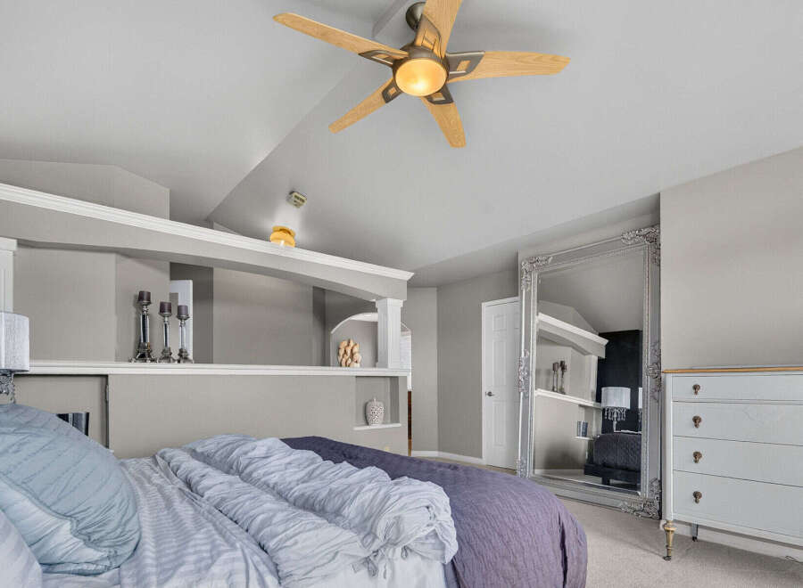 Experience luxury and comfort in this master bedroom, featuring a plush bed with elegant bedding and a stunning ornate floor mirror that amplifies the space.