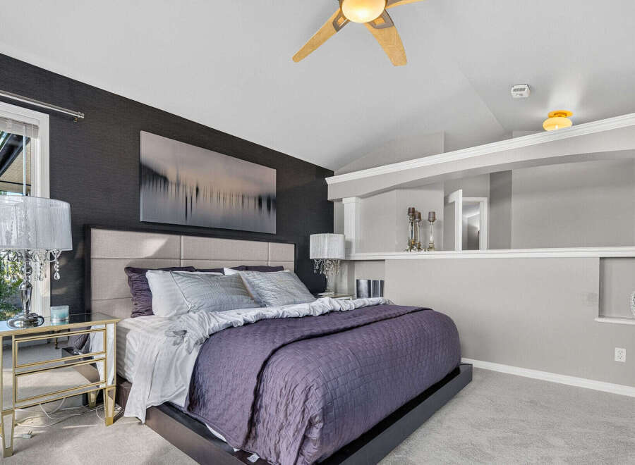 Experience modern luxury in this master bedroom, featuring a sophisticated dark textured wallpaper accent wall behind a plush upholstered headboard.