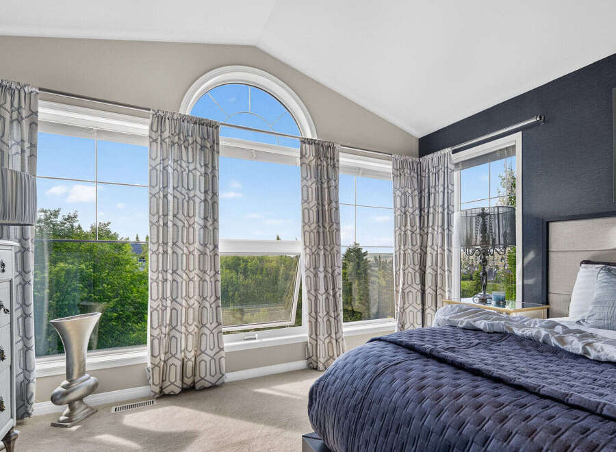 Experience breathtaking views from this stunning bedroom, featuring expansive windows that flood the space with natural light.