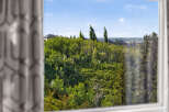 Enjoy the serene views from this property, offering a lush green landscape dotted with mature trees and glimpses of charming homes.