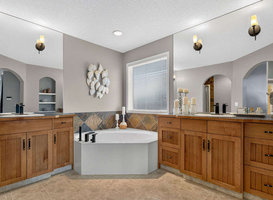 Indulge in luxury with this stunning master bathroom, featuring a spacious corner soaking tub perfect for relaxation.