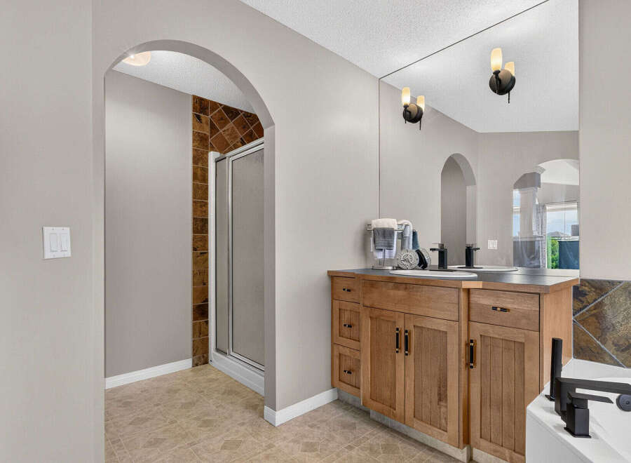 Step into this elegant bathroom featuring a spacious vanity with ample storage and a large mirror, perfect for your morning routine.