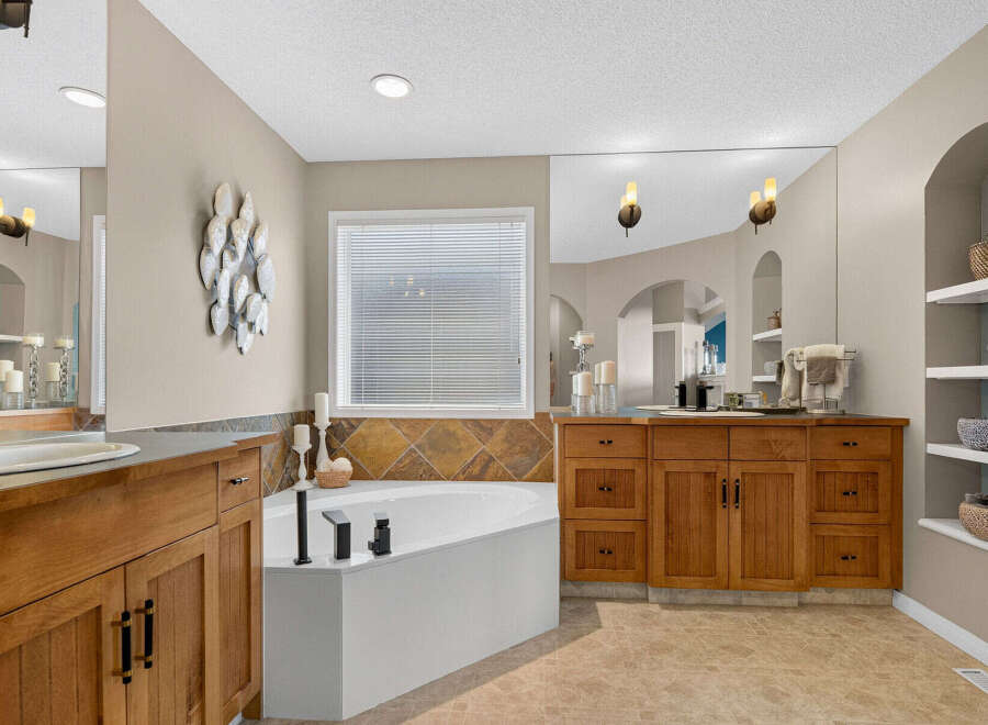 Indulge in luxury in this stunning master bathroom, featuring a spacious corner jacuzzi tub perfect for relaxation.