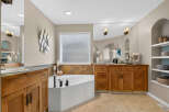 Indulge in luxury in this stunning master bathroom, featuring a spacious corner jacuzzi tub perfect for relaxation.