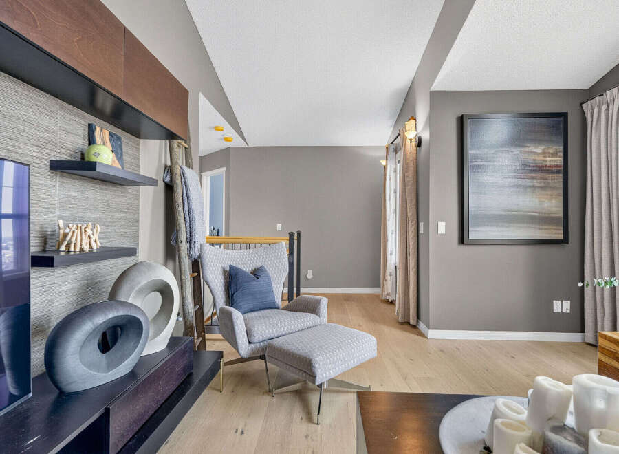 Experience modern living in this stylish living room, featuring a comfortable armchair with an ottoman, perfect for relaxation.
