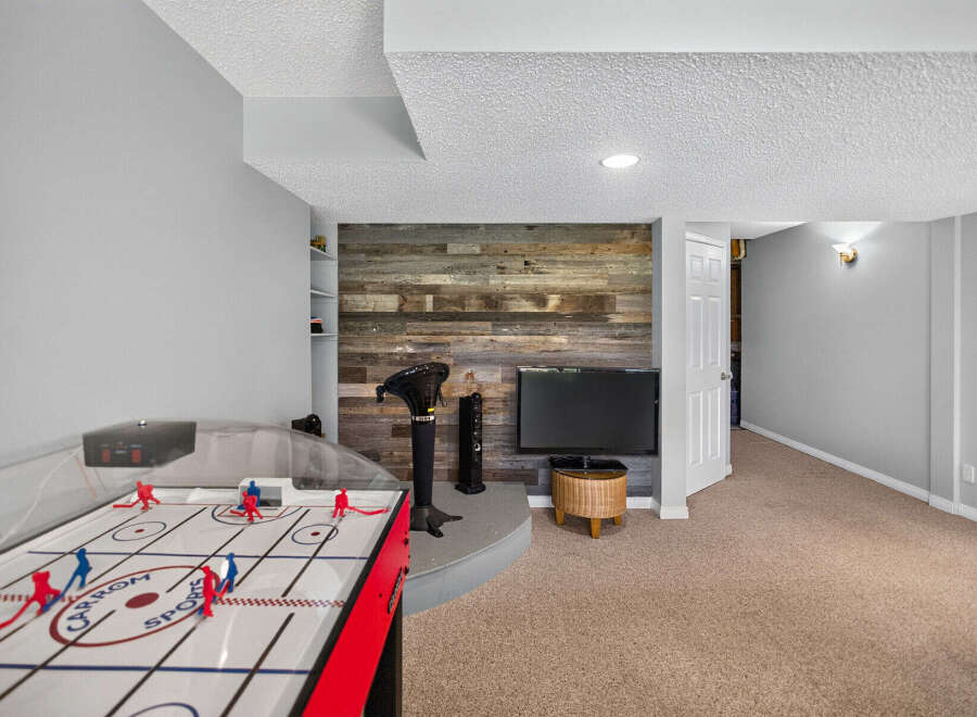 This basement recreation room offers a perfect blend of entertainment and relaxation.