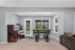 This inviting space features a classic upright piano, perfect for musical enjoyment, adjacent to a glass-paned door leading outdoors.