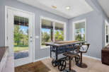 Enjoy indoor-outdoor living with this charming space featuring a stylish bar-height table and stools, perfect for casual dining or entertaining.
