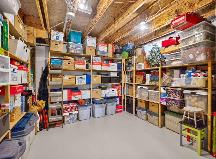 Maximize your storage potential with this well-organized basement, featuring ample shelving units filled with various storage bins and boxes.