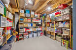 Maximize your storage potential with this well-organized basement, featuring ample shelving units filled with various storage bins and boxes.