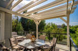 Enjoy outdoor living under this beautiful pergola, offering a shaded dining area with a glass-top table and comfortable seating.