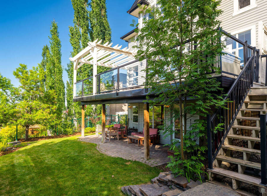 Enjoy outdoor living with this spacious backyard featuring a multi-level deck and a covered patio perfect for entertaining.