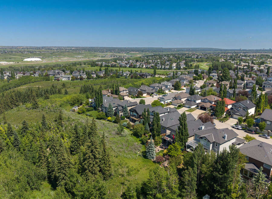 Discover this stunning aerial view of a suburban neighborhood, showcasing a collection of modern homes nestled amongst lush greenery and mature trees.