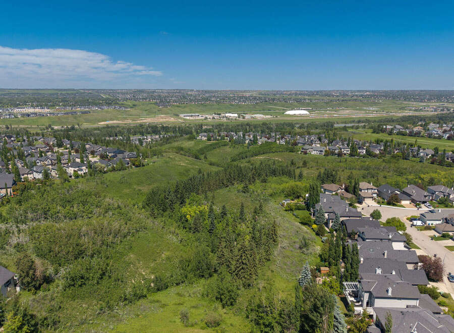 Discover this stunning aerial view showcasing a sprawling suburban landscape with modern homes nestled amidst lush greenery and rolling hills.