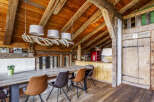 Experience rustic charm in this dining area featuring a large wooden table surrounded by stylish chairs.