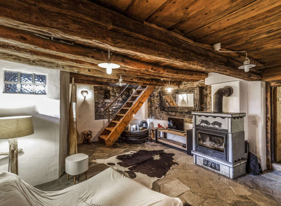 Experience rustic charm in this unique mountain retreat, featuring exposed wooden beams and a stone fireplace.