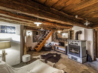 Experience rustic charm in this unique mountain retreat, featuring exposed wooden beams and a stone fireplace.