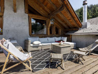 Enjoy the stunning mountain views from this charming wooden chalet's expansive deck, perfect for outdoor living.