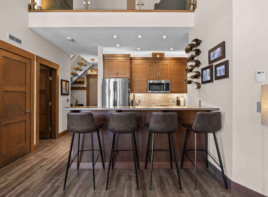 Experience modern living in this stunning condo featuring a sleek kitchen with stainless steel appliances and a spacious breakfast bar perfect for entertaining.