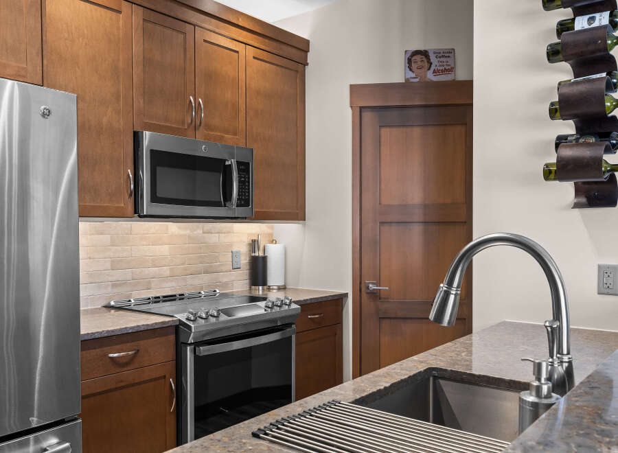 Experience modern living in this beautifully appointed kitchen, featuring sleek stainless steel appliances including a GE refrigerator and microwave.