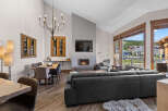 Experience luxury mountain living in this stunning condo, featuring a modern living space with a cozy fireplace and a spacious sectional sofa perfect for gatherings.