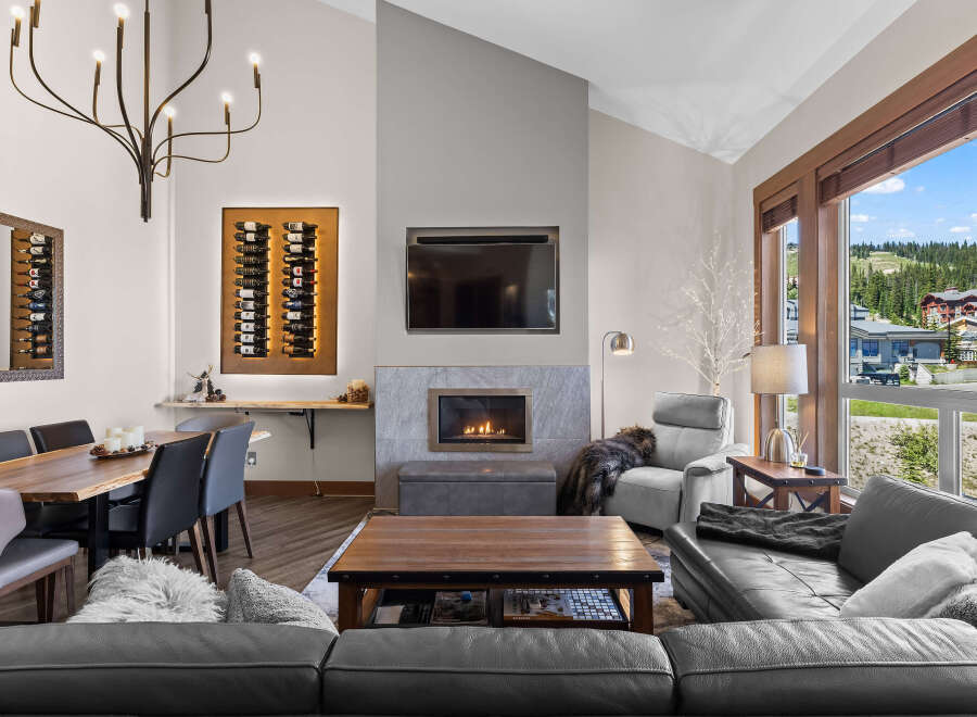 Experience luxury mountain living in this stunning great room, featuring a modern gas fireplace and a sleek entertainment center.
