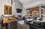 Experience luxury living in this stunning mountain retreat, featuring a spacious living area with a modern fireplace and a large window showcasing breathtaking views.