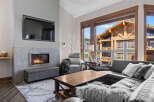 Experience modern mountain living in this stunning living room featuring a sleek gas fireplace and a large sectional sofa perfect for cozy evenings.