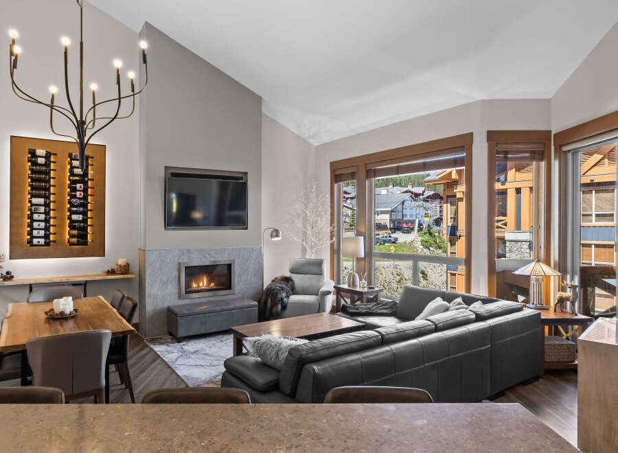 Experience luxury mountain living in this stunning condo, featuring a modern gas fireplace and a sleek, integrated entertainment system.