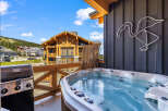 Enjoy ultimate relaxation on this private balcony, complete with a bubbling hot tub and a premium grill, perfect for outdoor entertaining.