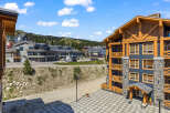 Experience mountain living in this stunning property featuring a modern exterior with stone and wood accents.