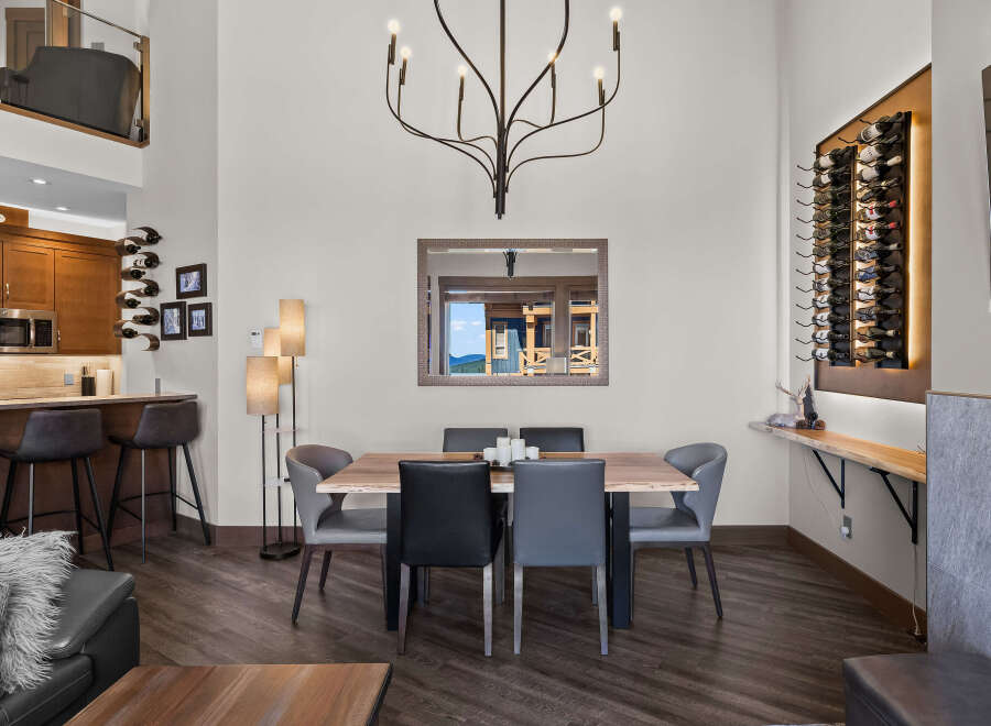 Experience modern living in this stunning dining area, featuring a sleek wooden dining table surrounded by comfortable upholstered chairs.