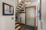 Step into this inviting entryway featuring a modern floating staircase with carpeted treads and a sleek metal railing.