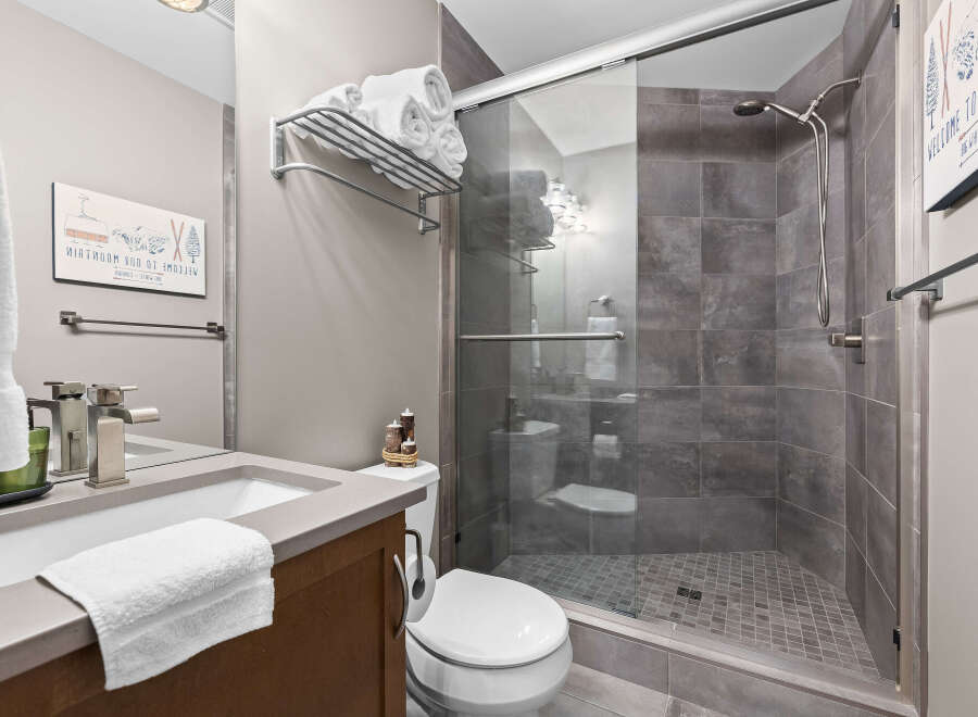 Experience modern comfort in this beautifully appointed bathroom, featuring a sleek vanity with a stylish faucet and a plush white towel.
