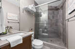 Experience modern comfort in this beautifully appointed bathroom, featuring a sleek vanity with a stylish faucet and a plush white towel.