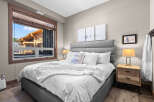 Experience ultimate comfort in this beautifully appointed bedroom, featuring a plush king-sized bed adorned with crisp white linens and a cozy faux fur throw.