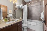 This modern bathroom features a sleek vanity with a vessel sink and brushed nickel fixtures, complemented by a large mirror and elegant lighting.