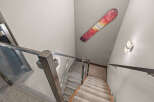 Ascend or descend in style with this modern staircase featuring sleek glass railings and plush carpeted steps.