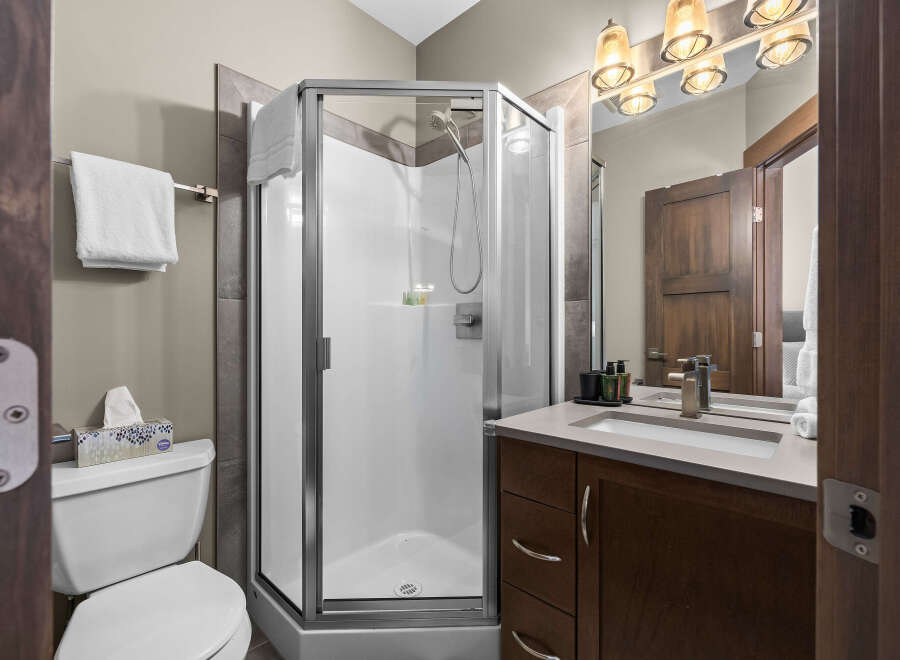 This modern bathroom features a sleek glass-enclosed shower and a stylish vanity with a vessel sink.