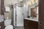 This modern bathroom features a sleek glass-enclosed shower and a stylish vanity with a vessel sink.