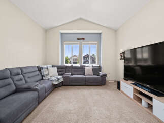 Step into this inviting living room, featuring a spacious sectional sofa perfect for family gatherings and a large television for entertainment.