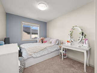 Discover this charming bedroom featuring a cozy bed adorned with plush bedding and decorative pillows.