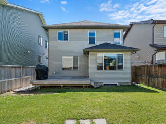 Enjoy outdoor living in this spacious backyard featuring a wooden deck perfect for entertaining and a well-maintained lawn.