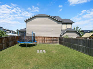 Enjoy outdoor fun in this spacious backyard, complete with a trampoline for endless entertainment.