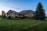 Experience luxury living in this stunning stone-clad residence, perfectly situated at dusk.