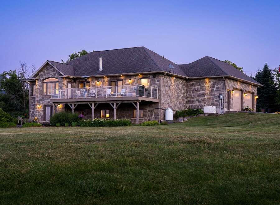 This stunning stone-clad home offers a luxurious lifestyle with a spacious elevated deck perfect for entertaining and enjoying the twilight views.